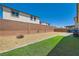 Large backyard with gravel, brick wall, and artificial turf sections at 3716 W Colton Ave, North Las Vegas, NV 89032