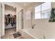 Bright bathroom showcasing a soaking tub with a glass-enclosed shower and walk-in closet at 3716 W Colton Ave, North Las Vegas, NV 89032