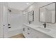 Bathroom with a double sink vanity, framed mirrors, and a shower over tub with white subway tiles at 4132 Joyous St, North Las Vegas, NV 89032