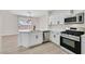 Well-lit kitchen featuring modern appliances, white cabinetry, and a functional layout at 4132 Joyous St, North Las Vegas, NV 89032