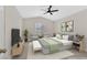 Bedroom with ceiling fan, bed with padded headboard, end tables and seating for two at 4132 Joyous St, North Las Vegas, NV 89032