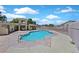 Community pool area with a unique pool shape, surrounding fencing and a sunny sky at 4132 Joyous St, North Las Vegas, NV 89032