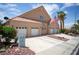 Front exterior of a well-maintained home with a three car garage and desert landscaping at 414 Crystal Canyon Dr, Mesquite, NV 89027
