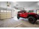 Bright garage featuring a red Jeep Rubicon and an open door to the outdoors at 414 Crystal Canyon Dr, Mesquite, NV 89027