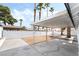 Spacious backyard featuring a covered patio, mature trees, and a white-painted cinder block perimeter fence at 4312 Chrysalis Dr, Las Vegas, NV 89121
