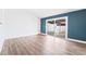 Bright living room with hardwood flooring, a blue accent wall, and sliding glass doors to the backyard at 4312 Chrysalis Dr, Las Vegas, NV 89121