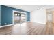Bright living room with blue accent wall, wood-look floors, and sliding glass doors to the patio at 4312 Chrysalis Dr, Las Vegas, NV 89121