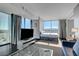 Bright living room with TV, floor-to-ceiling windows, and a comfortable seating area next to a cozy bed at 4381 W Flamingo Rd # 1121, Las Vegas, NV 89103