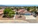 This home features desert landscaping, a two-car garage, and mature trees, nestled in a residential area at 475 E Robindale Rd, Las Vegas, NV 89123