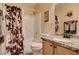 Cozy bathroom featuring a granite vanity top, framed mirror, and a shower with a decorative curtain at 5043 Mascaro Dr, Las Vegas, NV 89122