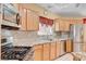 Modern kitchen with stainless appliances, light wood cabinets, and beautiful granite countertops at 5043 Mascaro Dr, Las Vegas, NV 89122