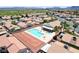 Aerial view of a community pool area featuring lounge chairs, a covered patio, palm trees, and well-maintained residences at 5043 Mascaro Dr, Las Vegas, NV 89122