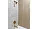 The walk-in shower has both white subway tiles, textured tan accent tiles and gold hardware at 5191 Caliente St # 84, Las Vegas, NV 89119