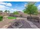 Beautiful backyard featuring a fire pit, mature landscaping, a covered patio, and desert surroundings at 5437 Escallonia St, Las Vegas, NV 89149