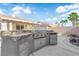 Entertainer's backyard with a built-in barbecue, covered patio, desert landscaping, and rock features at 5437 Escallonia St, Las Vegas, NV 89149