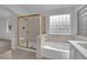 Bright bathroom showcasing a bathtub, shower and clear glass block window at 5437 Escallonia St, Las Vegas, NV 89149