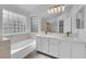Bright bathroom featuring double sinks, marble countertops, and a separate bathtub at 5437 Escallonia St, Las Vegas, NV 89149