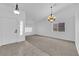 Living room featuring carpet, shuttered windows, and chandelier lighting at 5437 Escallonia St, Las Vegas, NV 89149
