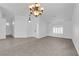 Inviting living room with plush carpeting, chandelier lighting, and arched window at 5437 Escallonia St, Las Vegas, NV 89149