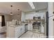 Efficient kitchen with stainless steel appliances, white cabinets, and modern lighting fixtures with convenient breakfast bar at 5710 E Tropicana Ave # 1216, Las Vegas, NV 89122