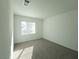 Bright bedroom with plush carpeting and a window view of neighboring homes at 5904 Becklow Gardens Ave, Las Vegas, NV 89141