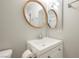 Well-lit bathroom with a round mirror, a white sink, and a single-door vanity cabinet at 595 Sellers Pl, Henderson, NV 89011
