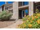 Charming condo entrance with desert landscaping featuring vibrant flowers and a secure, gated doorway at 595 Sellers Pl, Henderson, NV 89011
