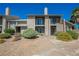 Charming condo complex with balconies, desert landscaping, gravel, and palm trees against a blue sky at 595 Sellers Pl, Henderson, NV 89011