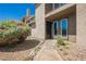 Inviting condo entrance framed by desert landscaping and blooming flowers, leading to a secure, gated door at 595 Sellers Pl, Henderson, NV 89011