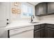 Kitchen detail with stainless steel sink, white countertop, grey cabinets, and updated fixtures at 595 Sellers Pl, Henderson, NV 89011