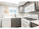 Cozy kitchen with white appliances, grey cabinets, a window over the sink, and bright natural lighting at 595 Sellers Pl, Henderson, NV 89011