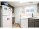 Well-lit kitchen with stainless steel sink, white appliances, grey cabinets, and wood-look flooring at 595 Sellers Pl, Henderson, NV 89011