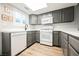 Classic kitchen featuring white appliances, stylish grey cabinets, and abundant natural light at 595 Sellers Pl, Henderson, NV 89011