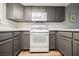 Updated kitchen with grey cabinets, white oven and microwave, and plenty of storage space at 595 Sellers Pl, Henderson, NV 89011