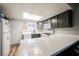 Bright kitchen with grey cabinets, white appliances, and quartz countertops with natural light from the skylight at 595 Sellers Pl, Henderson, NV 89011