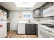 Charming kitchen featuring grey cabinets, white appliances and countertops, and wood-look flooring at 595 Sellers Pl, Henderson, NV 89011