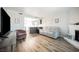 Spacious living room featuring modern wood floors and a painted brick fireplace at 595 Sellers Pl, Henderson, NV 89011