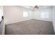 Bright, spacious bedroom with plush carpet, neutral walls, and ample natural light from two large windows at 6029 Allanche Ave, Las Vegas, NV 89141