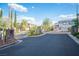 Gated community entrance with stone pillars, lush landscaping, and well-maintained asphalt at 6029 Allanche Ave, Las Vegas, NV 89141