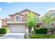 Charming two-story home with a well-manicured front yard and a two-car garage under a sunny sky at 6029 Allanche Ave, Las Vegas, NV 89141