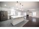 Modern kitchen with a large island open to a living room with hardwood flooring and a fireplace at 6029 Allanche Ave, Las Vegas, NV 89141