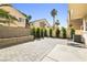 Private backyard with a paved patio, bordered by manicured shrubs and trees at 6050 Golden Corral Trl # 102, Henderson, NV 89011