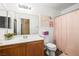 Cozy bathroom featuring a wood vanity, mirror, and shower with decorative pink curtain at 6050 Golden Corral Trl # 102, Henderson, NV 89011