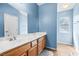 Clean bathroom featuring a single sink vanity, mirror, and wood-look flooring at 6050 Golden Corral Trl # 102, Henderson, NV 89011