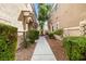 Charming townhomes with stucco exteriors and landscaped walkway to a backyard gate at 6050 Golden Corral Trl # 102, Henderson, NV 89011