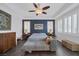 Comfortable bedroom features a dark accent wall, a ceiling fan, and white plantation shutters at 6173 Sabine Ranch Rd, Las Vegas, NV 89131