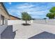 Expansive backyard featuring decorative rocks, a tree, and block wall for privacy at 6204 Robin Hood Cir, Las Vegas, NV 89108