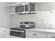 Modern kitchen featuring stainless steel appliances, marble countertops, and white cabinets with gold accents at 6204 Robin Hood Cir, Las Vegas, NV 89108