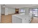 A modern kitchen flows into the living room with the brick fireplace and new flooring throughout at 6204 Robin Hood Cir, Las Vegas, NV 89108