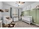 Cozy Bedroom featuring a crib, comfortable chair, stylish decor and ample natural light at 6318 Amber Sunrise St, North Las Vegas, NV 89031